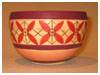 A Bali stoneware bowl, decorated with geometric design with 4 leaves on peach colour background - first view.