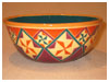 A Bali stoneware wide bowl, decorated with geometric design diamonds and triangle shapes in vibrant colour glazes - first view.