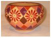 A Bali stoneware round shape bowl, decorated with geometric design with diamond shaps and daisies in autumn colours - third view.