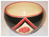 A Bali stoneware round bowl, decorated with poppies in geomatric shapes on black background - first view.