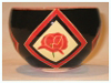 A Bali stoneware round bowl, decorated with poppies in geomatric shapes on black background - third view.