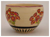 A Bali stoneware pot decorated with primula flowers on cream background - third view.