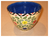 A Bali stoneware bowl, decorated with colourful daisies and leaves - first view.
