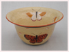 A Bali stoneware pot, glazed with 6 large butterflies on cream colour background - third view.